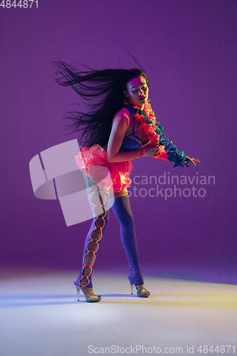 Image of Attractive hawaiian brunette model on purple studio background in neon light
