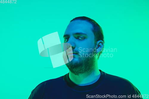 Image of Portrait of a guy with colorful neon light on green background - cyberpunk concept