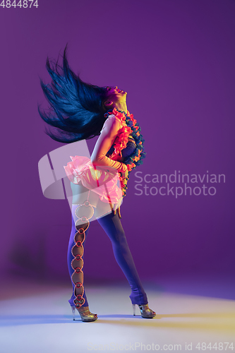 Image of Attractive hawaiian brunette model on purple studio background in neon light