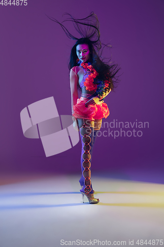 Image of Attractive hawaiian brunette model on purple studio background in neon light