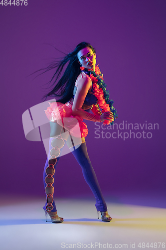 Image of Attractive hawaiian brunette model on purple studio background in neon light