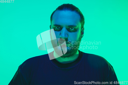 Image of Portrait of a guy with colorful neon light on green background - cyberpunk concept