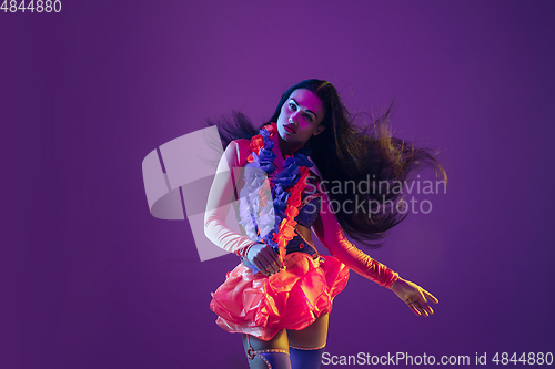 Image of Attractive hawaiian brunette model on purple studio background in neon light