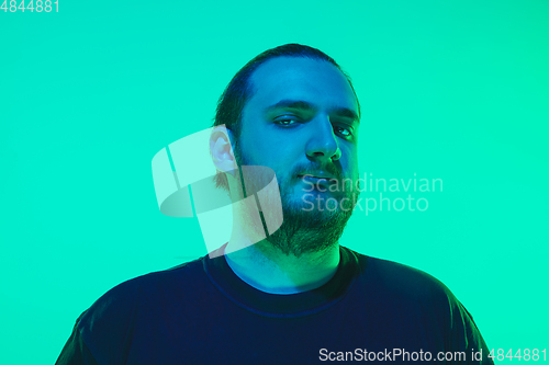 Image of Portrait of a guy with colorful neon light on green background - cyberpunk concept