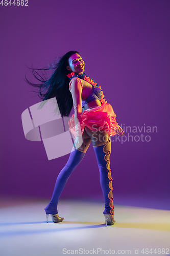 Image of Attractive hawaiian brunette model on purple studio background in neon light