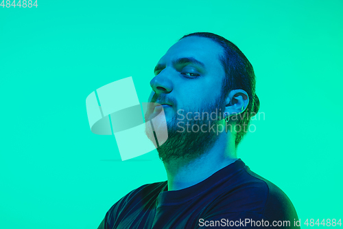 Image of Portrait of a guy with colorful neon light on green background - cyberpunk concept