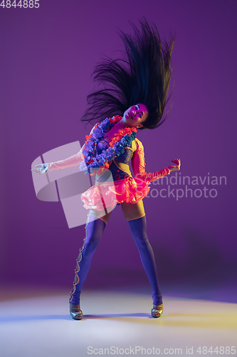 Image of Attractive hawaiian brunette model on purple studio background in neon light