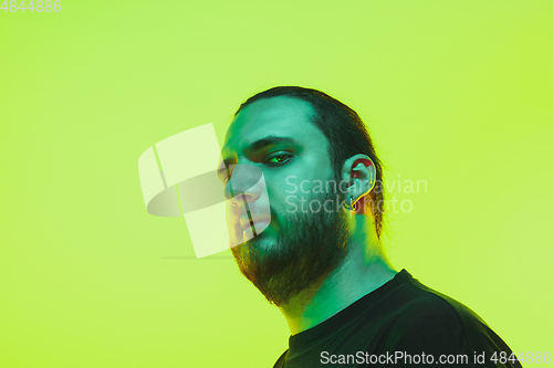 Image of Portrait of a guy with colorful neon light on green background - cyberpunk concept