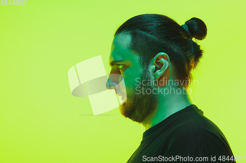 Image of Portrait of a guy with colorful neon light on green background - cyberpunk concept