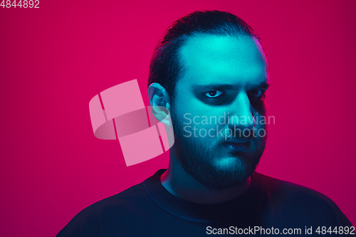 Image of Portrait of a guy with colorful neon light on pink background - cyberpunk concept