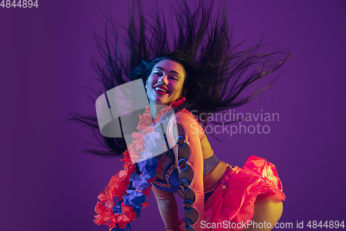 Image of Attractive hawaiian brunette model on purple studio background in neon light