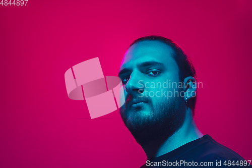 Image of Portrait of a guy with colorful neon light on pink background - cyberpunk concept