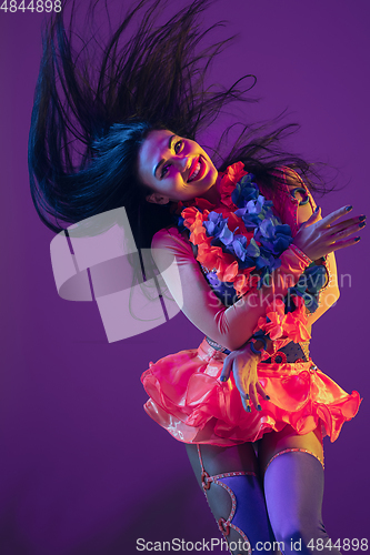 Image of Attractive hawaiian brunette model on purple studio background in neon light