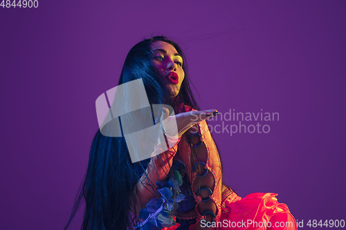 Image of Attractive hawaiian brunette model on purple studio background in neon light