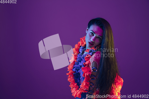 Image of Attractive hawaiian brunette model on purple studio background in neon light