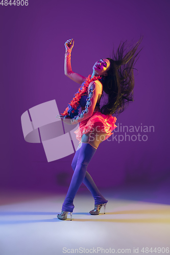 Image of Attractive hawaiian brunette model on purple studio background in neon light