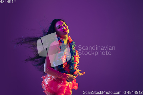 Image of Attractive hawaiian brunette model on purple studio background in neon light