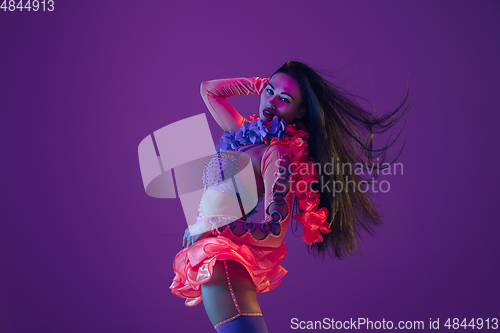 Image of Attractive hawaiian brunette model on purple studio background in neon light