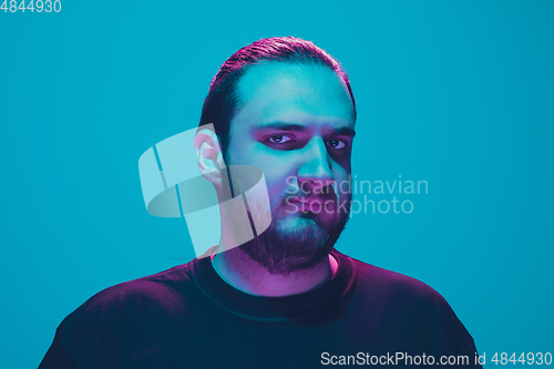 Image of Portrait of a guy with colorful neon light on blue background - cyberpunk concept