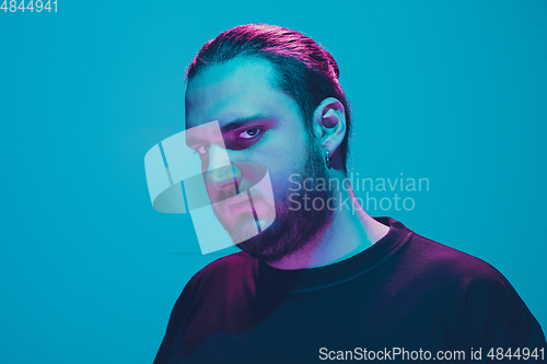 Image of Portrait of a guy with colorful neon light on blue background - cyberpunk concept