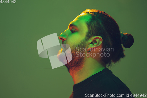 Image of Portrait of a guy with colorful neon light on green background - cyberpunk concept