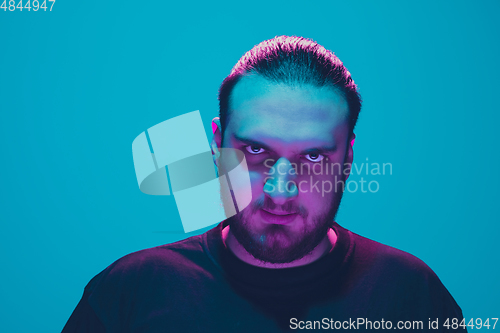 Image of Portrait of a guy with colorful neon light on blue background - cyberpunk concept