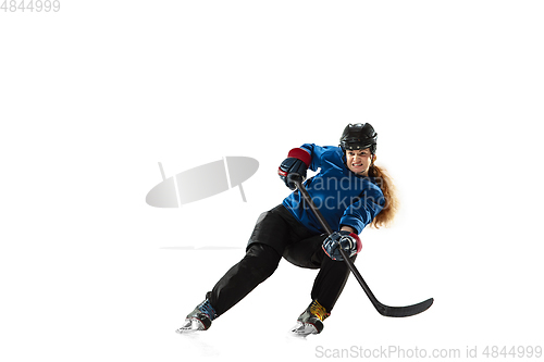 Image of Young female hockey player with the stick on ice court and white background