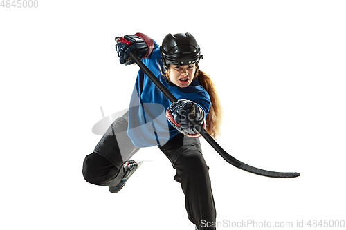 Image of Young female hockey player with the stick on ice court and white background