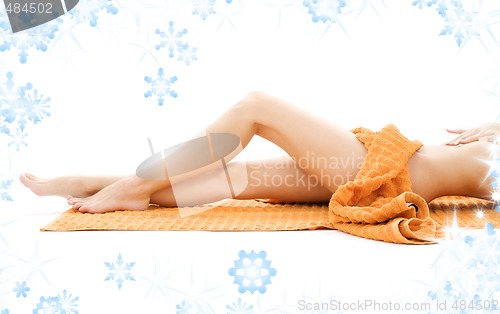 Image of long legs of relaxed lady with orange towel