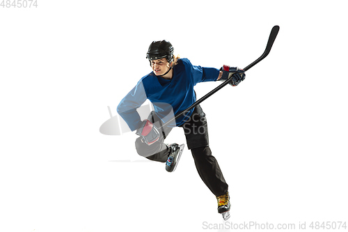 Image of Young female hockey player with the stick on ice court and white background