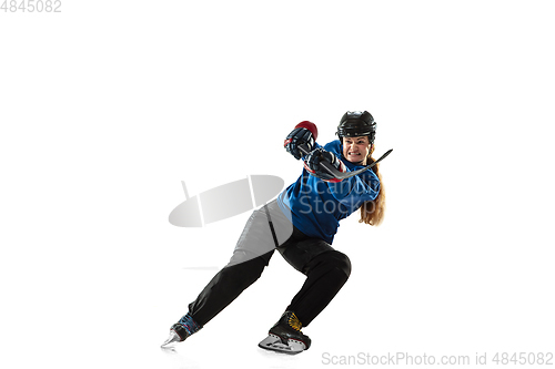 Image of Young female hockey player with the stick on ice court and white background