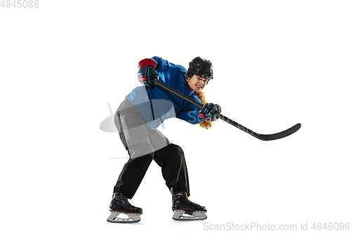 Image of Young female hockey player with the stick on ice court and white background