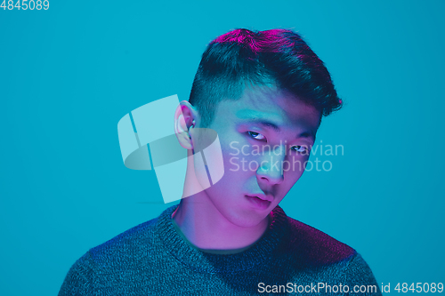 Image of Portrait of a guy with colorful neon light on blue background - cyberpunk concept