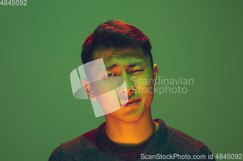 Image of Portrait of a guy with colorful neon light on green background - cyberpunk concept