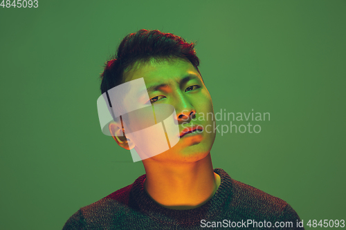 Image of Portrait of a guy with colorful neon light on green background - cyberpunk concept