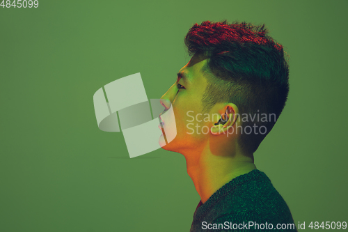 Image of Portrait of a guy with colorful neon light on green background - cyberpunk concept