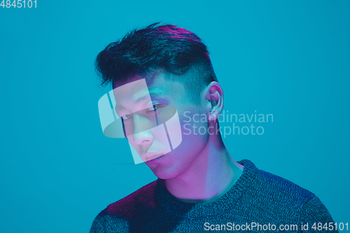 Image of Portrait of a guy with colorful neon light on blue background - cyberpunk concept
