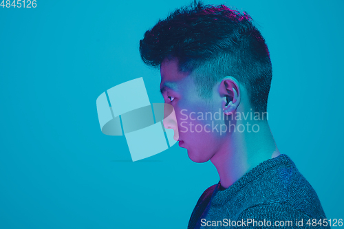 Image of Portrait of a guy with colorful neon light on blue background - cyberpunk concept