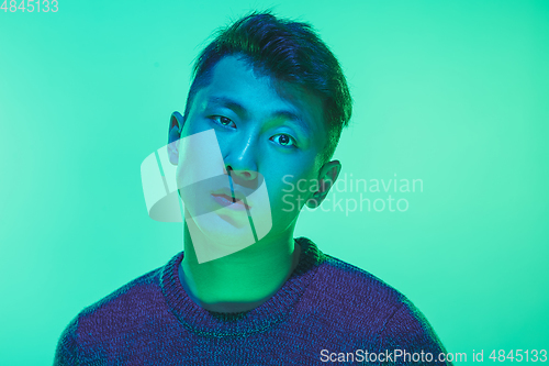 Image of Portrait of a guy with colorful neon light on green background - cyberpunk concept