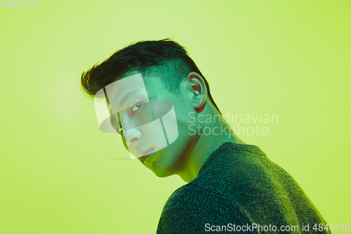 Image of Portrait of a guy with colorful neon light on yellow background - cyberpunk concept