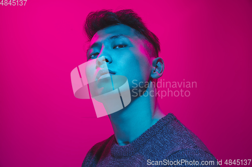 Image of Portrait of a guy with colorful neon light on pink background - cyberpunk concept