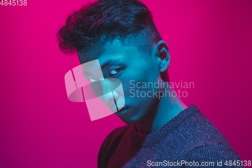 Image of Portrait of a guy with colorful neon light on pink background - cyberpunk concept