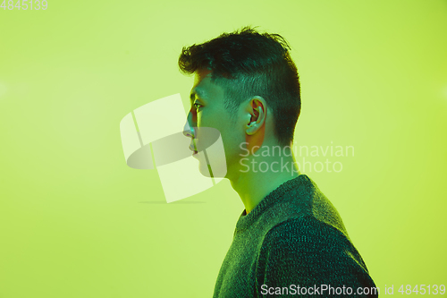 Image of Portrait of a guy with colorful neon light on yellow background - cyberpunk concept