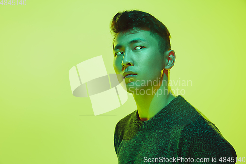 Image of Portrait of a guy with colorful neon light on yellow background - cyberpunk concept