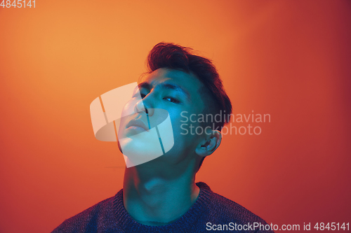 Image of Portrait of a guy with colorful neon light on gradient background - cyberpunk concept