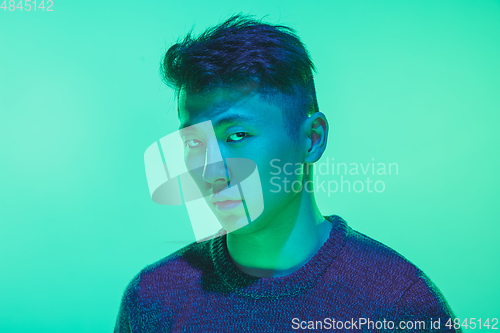 Image of Portrait of a guy with colorful neon light on green background - cyberpunk concept