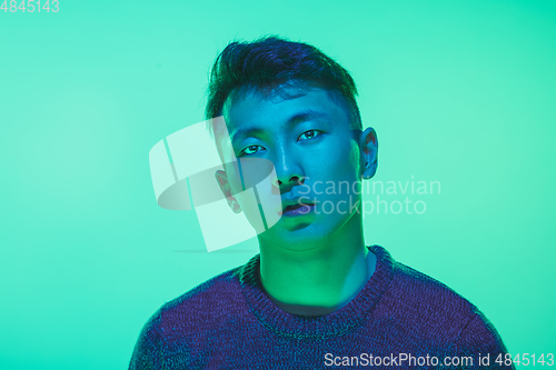 Image of Portrait of a guy with colorful neon light on green background - cyberpunk concept