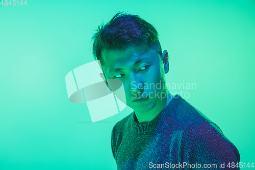 Image of Portrait of a guy with colorful neon light on green background - cyberpunk concept