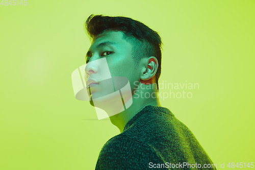 Image of Portrait of a guy with colorful neon light on yellow background - cyberpunk concept