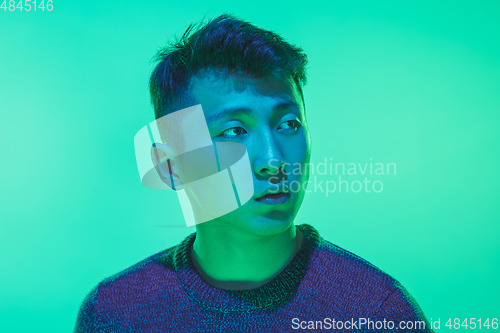 Image of Portrait of a guy with colorful neon light on green background - cyberpunk concept